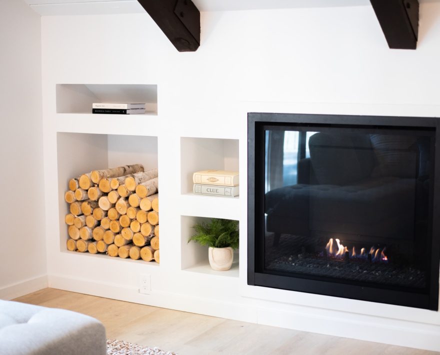 Cozy fireplace setting ideal for a Lake Arrowhead Family Vacation, featuring logs and books.