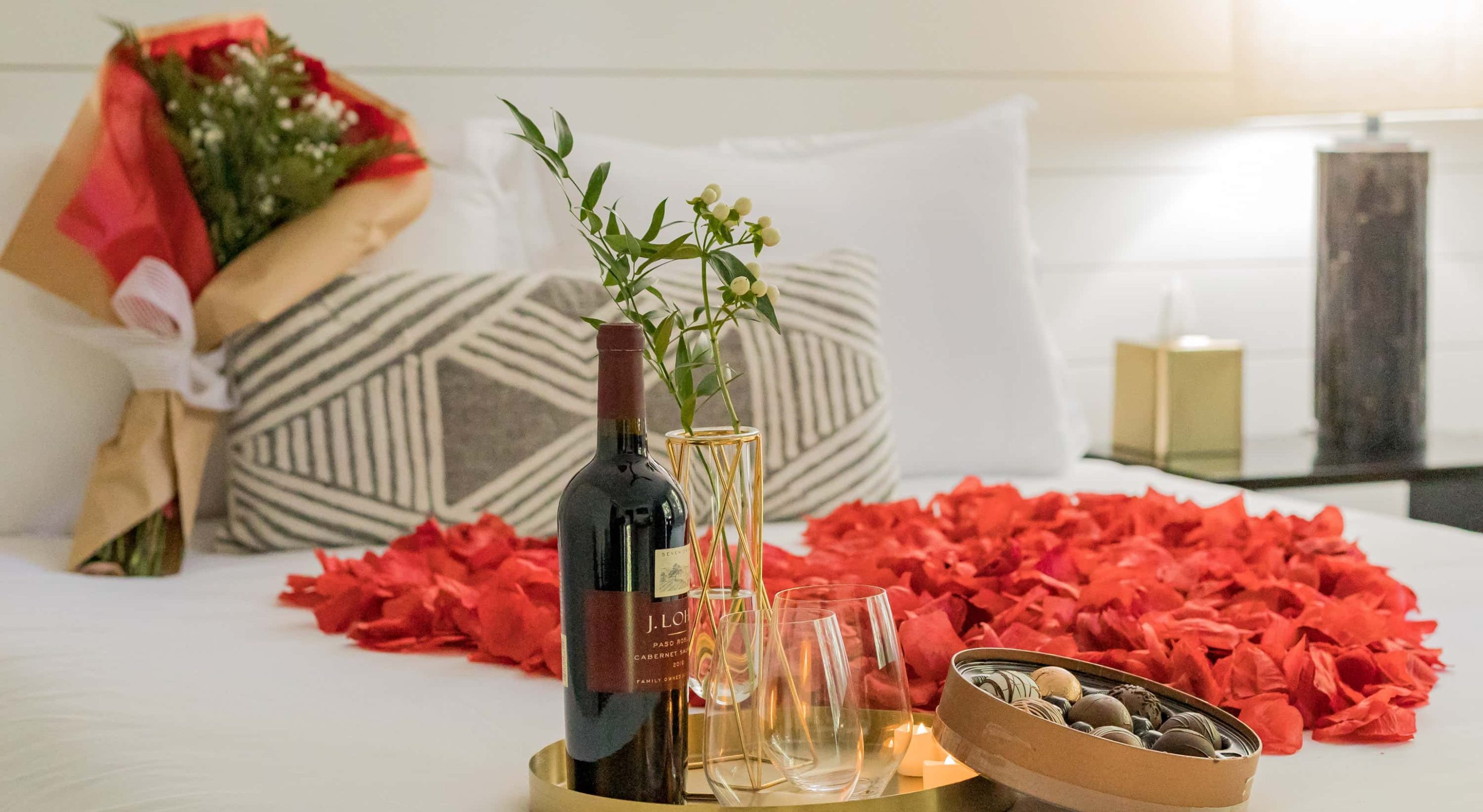 Romantic setting in a cozy mountain retreat with wine, roses, and chocolates.