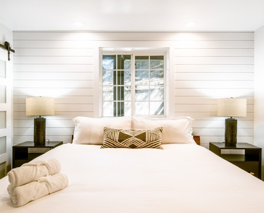 A cozy mountain retreat room features a plush bed, perfect for a Lake Arrowhead Escape.