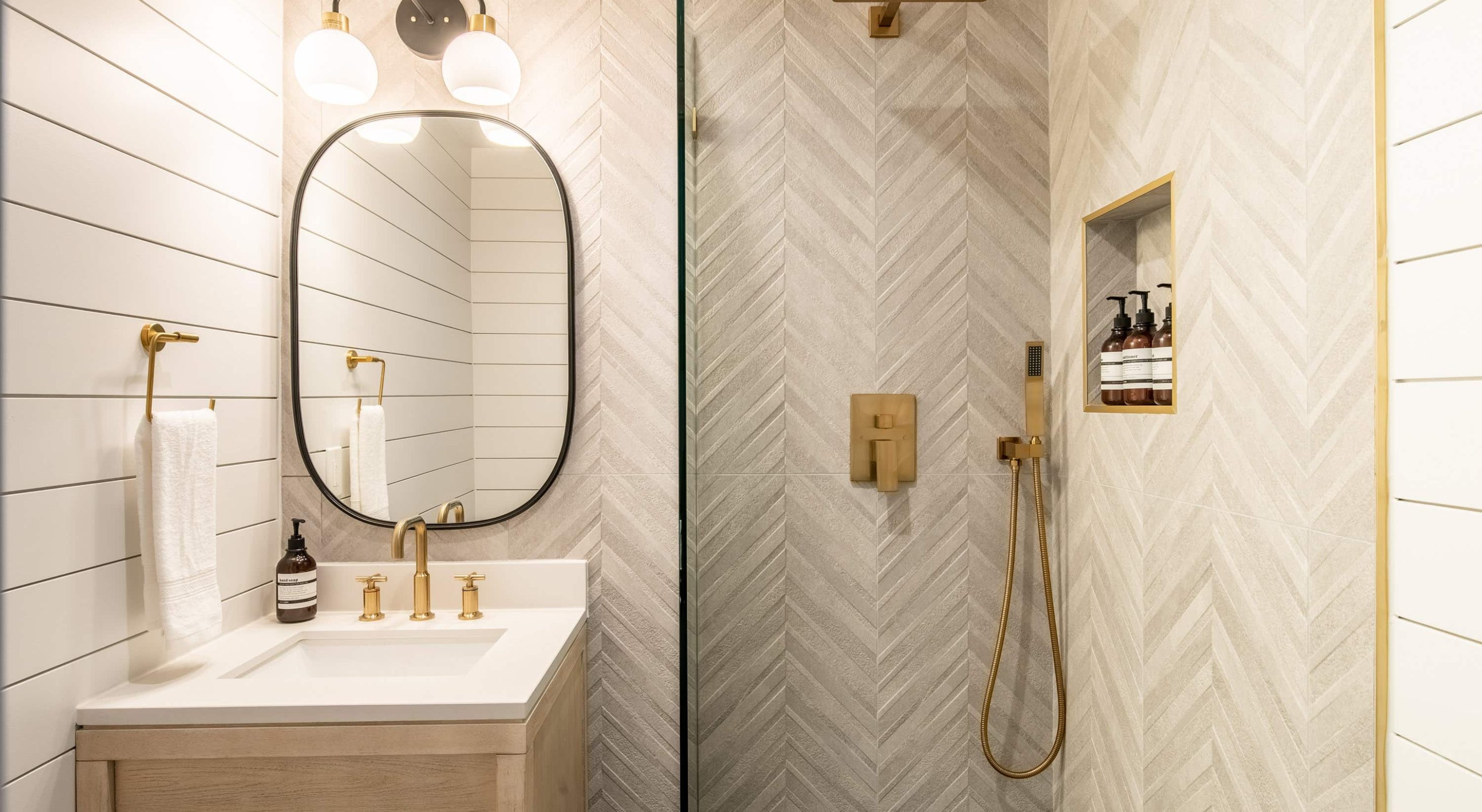 Modern bathroom in a Boutique Hotel Near The Village, featuring gold fixtures and tiles.