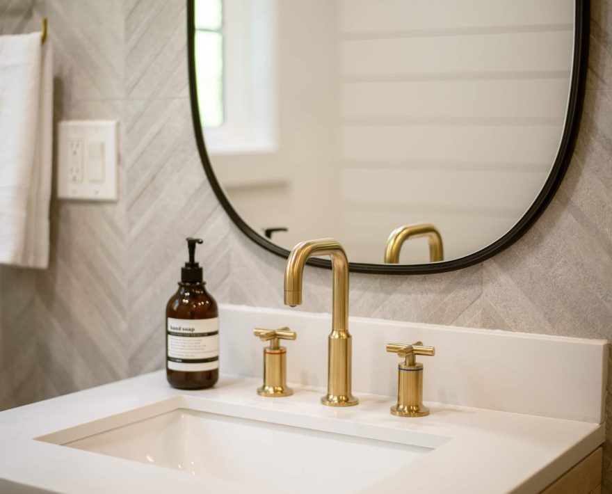 Elegant modern bathroom vanity in a Cozy Mountain Retreat, featuring gold fixtures.