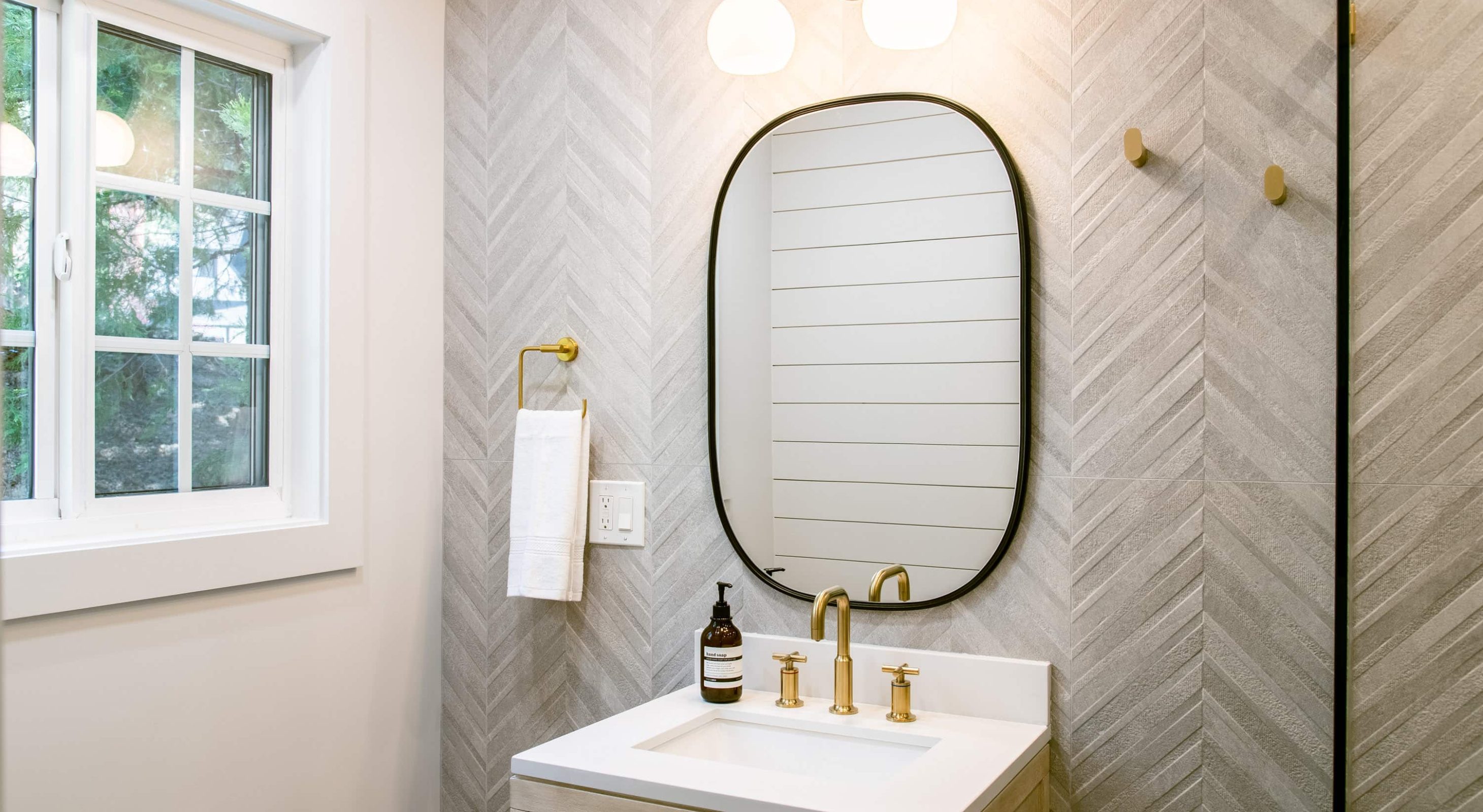 Modern bathroom with gold fixtures at a cozy mountain retreat, ideal for Lake Arrowhead Escape.