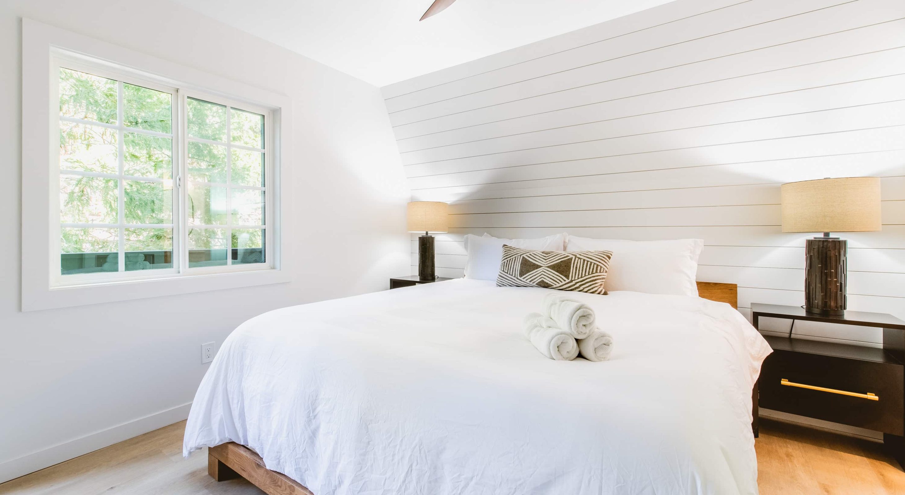 Cozy room with a white bed and window view at a boutique hotel near the Village.