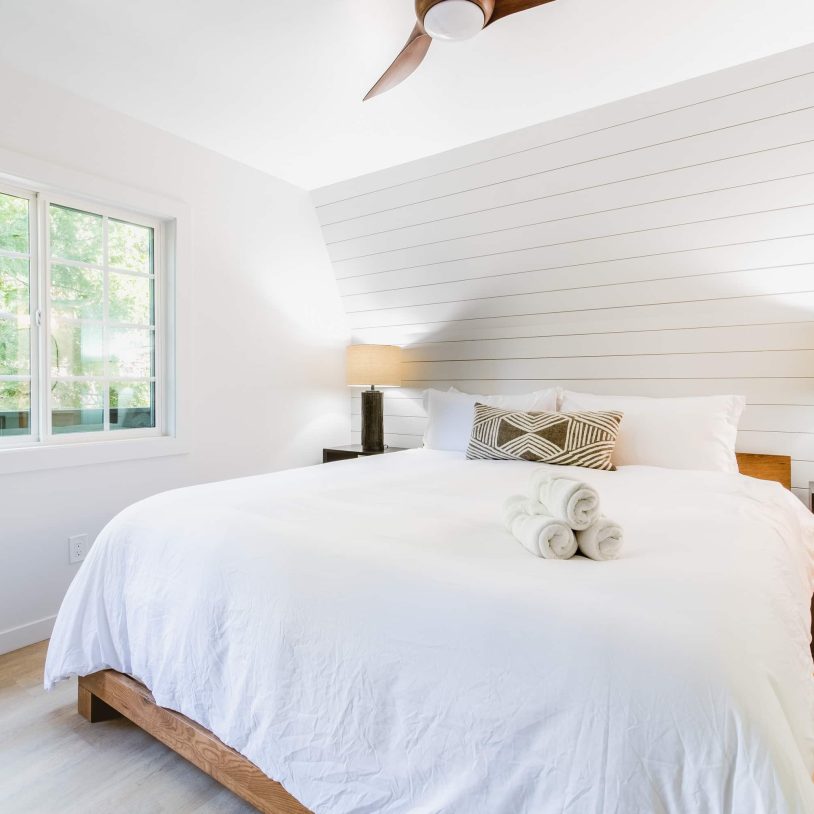 Cozy room with a white bed and window view at a boutique hotel near the Village.