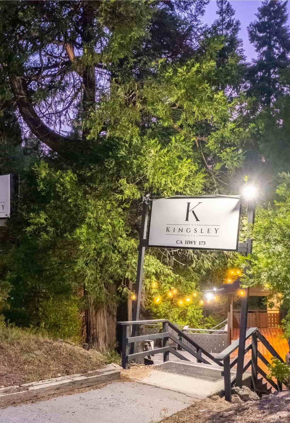 The Kingsley Hotel entrance at dusk, a serene Lake Arrowhead escape in forested setting.