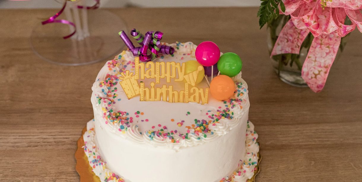 Birthday cake with flowers and balloons