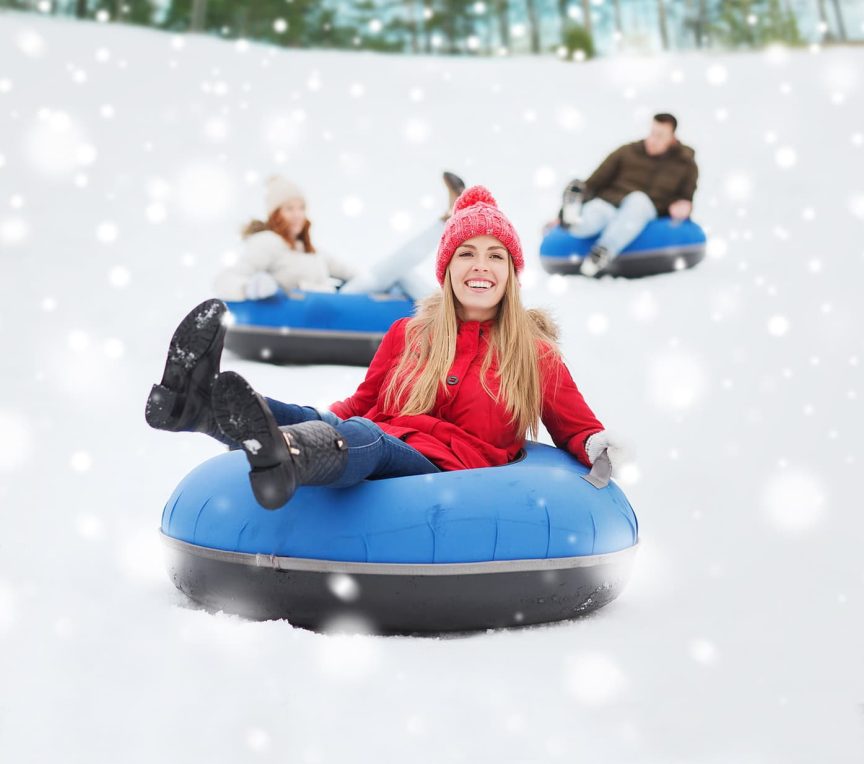 happy people snow tubing on mountain