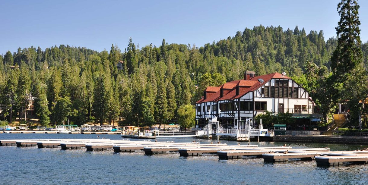 Charming lakeside view of a hotel nestled in the forest, ideal for a Lake Arrowhead Escape.