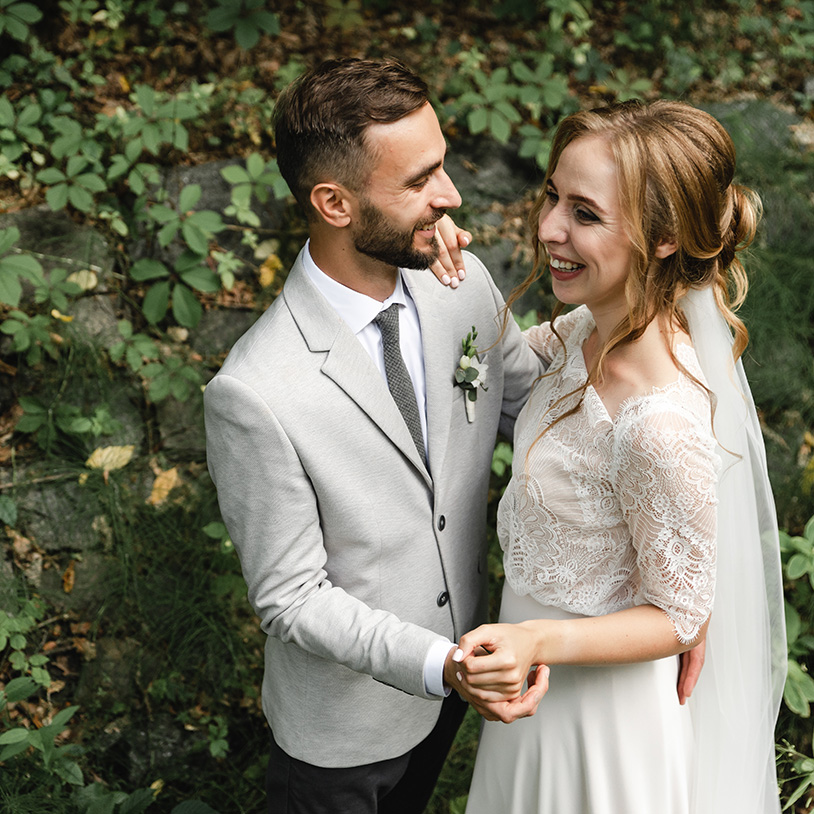 Happy couple embracing in a lush garden, perfect for a Lake Arrowhead family vacation.