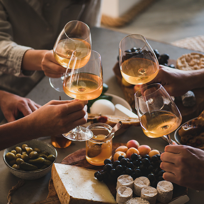 Friends toasting with wine and cheese, ideal for a cozy mountain retreat in Lake Arrowhead.